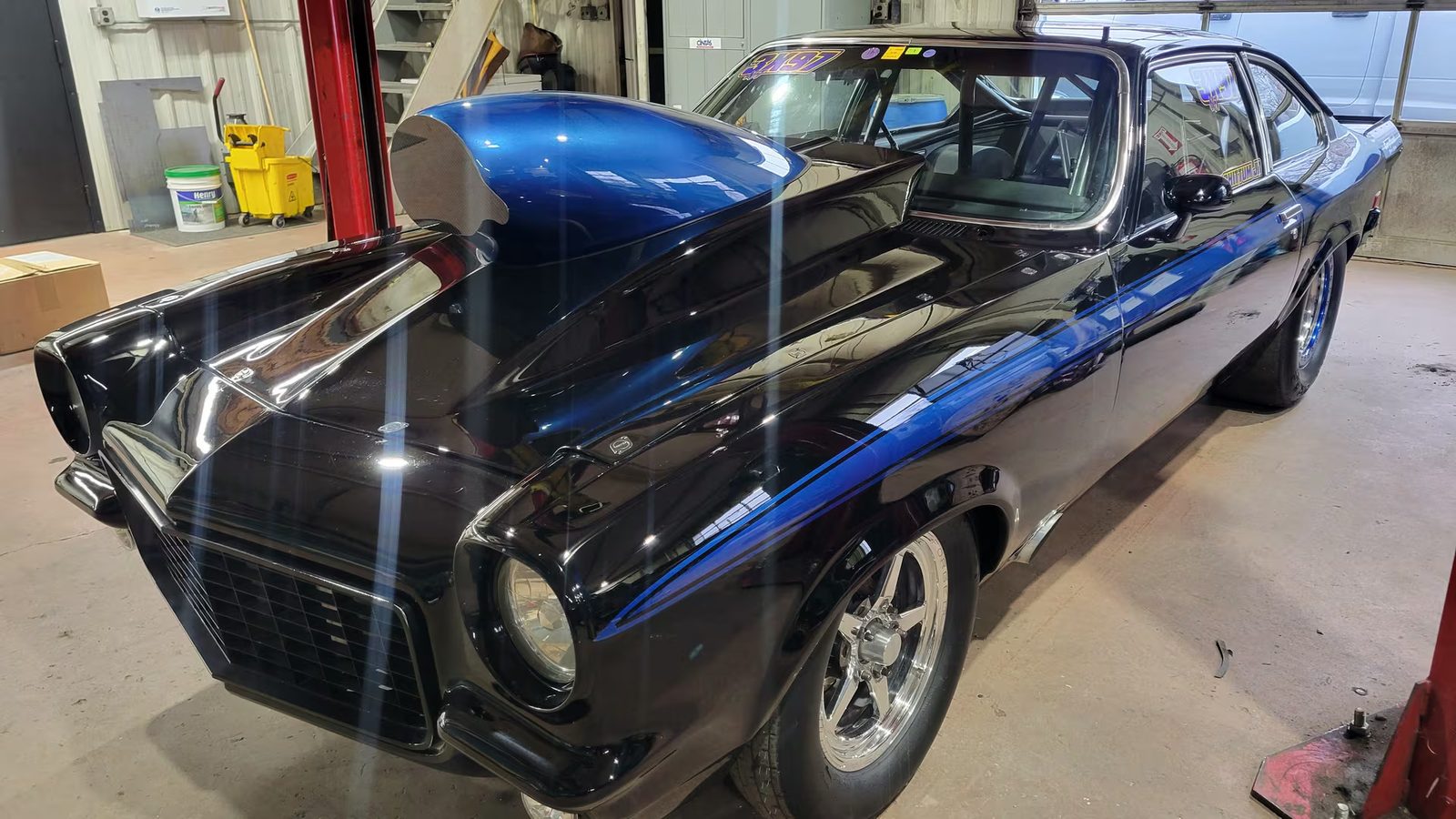 Classic muscle car with fresh two-tone paint parked inside the detailing shop